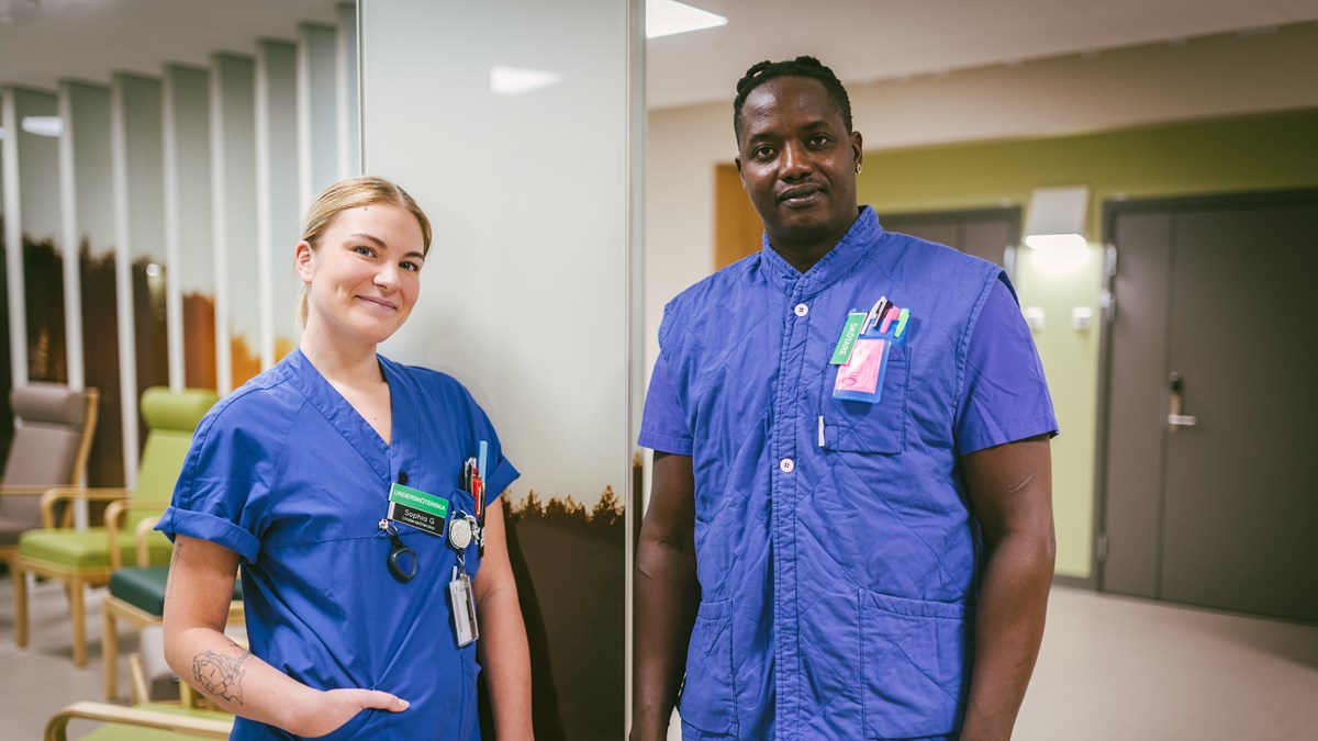 En kvinnlig och en manlig sjuksköterska i blåa sjukhuskläder
