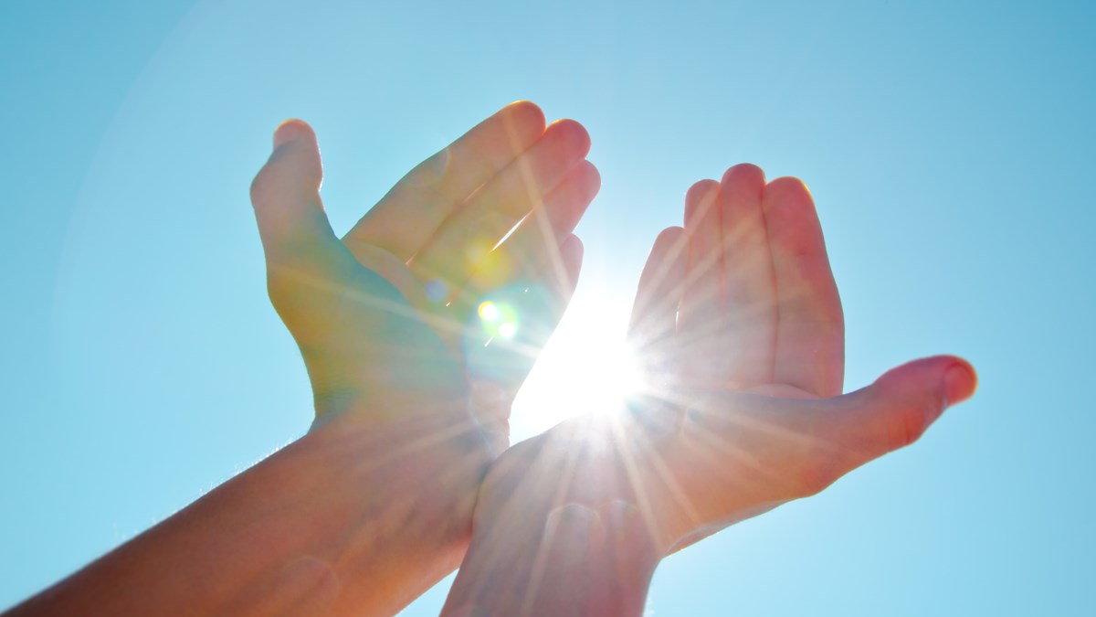 Solstrålar som fångas i två händer
