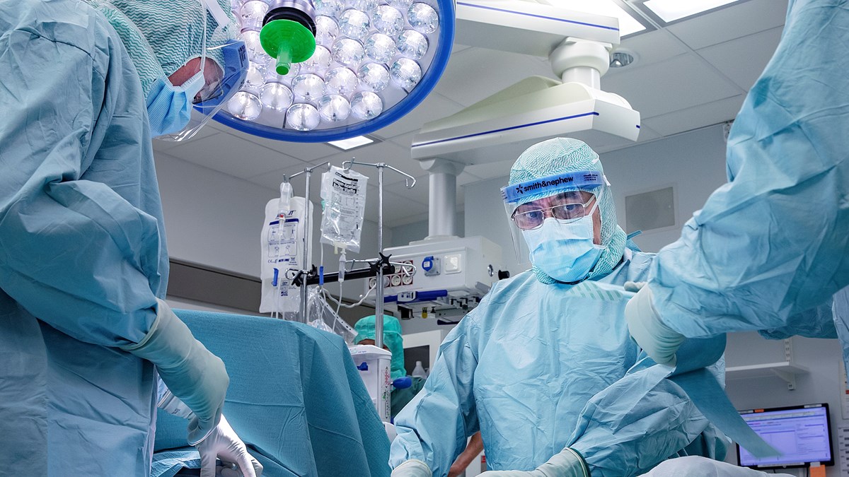 Kirurger opererar en patient i en operationssal.