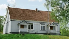 liten gråmålad byggnad med texten bygdegård på fasaden