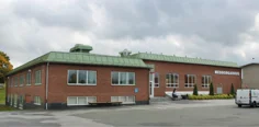 Låg tegelbyggnad med grönt tak och texten medborgarhus på fasaden