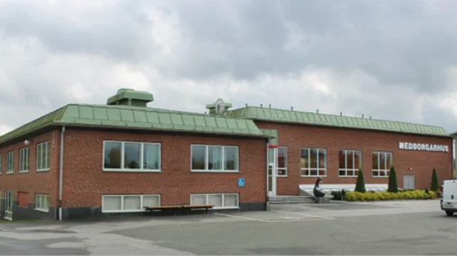 Låg tegelbyggnad med grönt tak och texten medborgarhus på fasaden