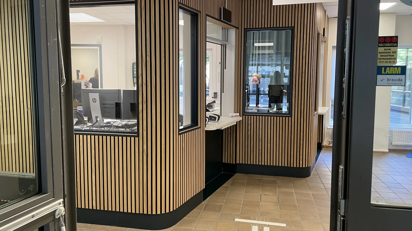 Inbyggd receptionen med fönster för att anmäla sig. Täckt av träpanel.