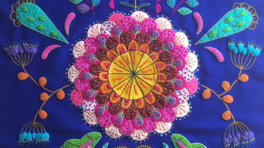 ett blått broderi med applikation i rosa