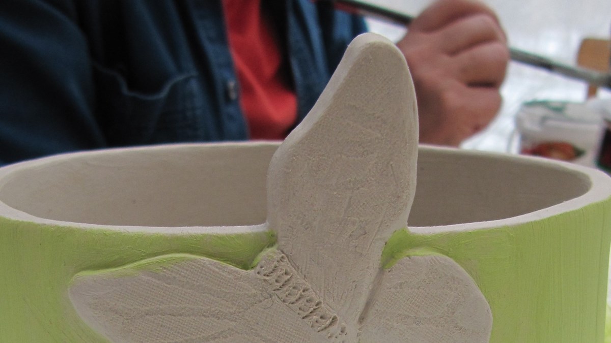 Grön skål i keramik med en fjäril på