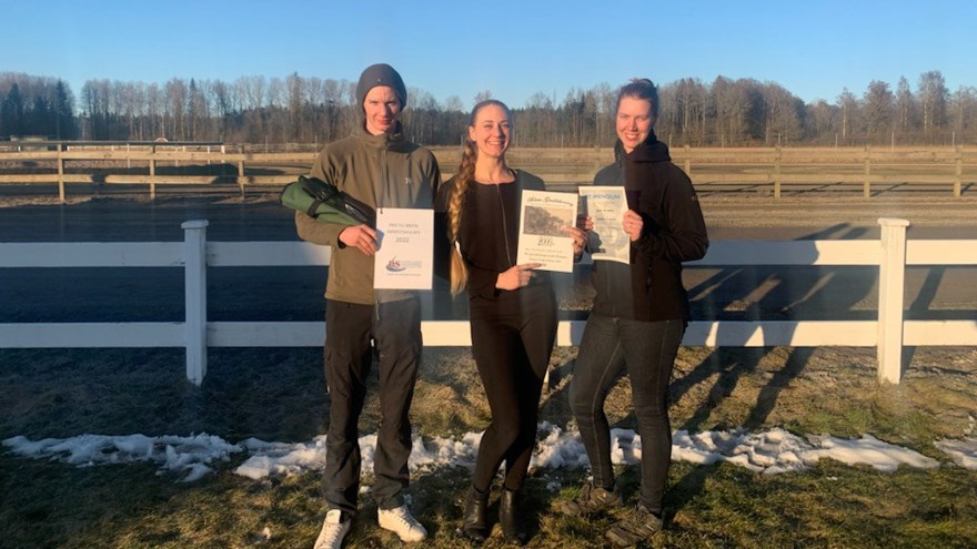 Tre hovslagarstuderanden visar upp sina stipendier utomhus