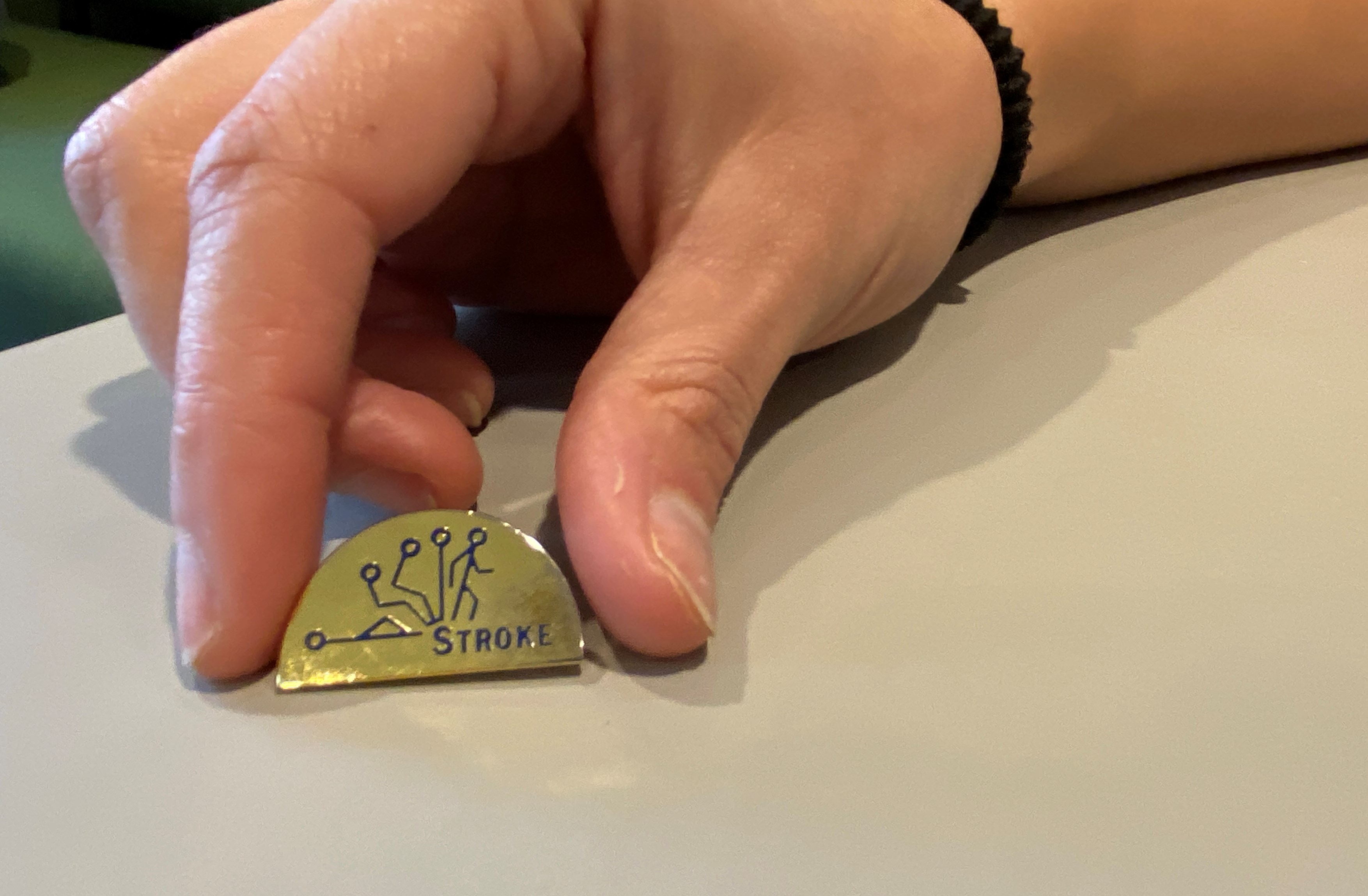 Pin som visar en streckguppe som ligger ner och därefter reser sig igen. Texten STROKE. 