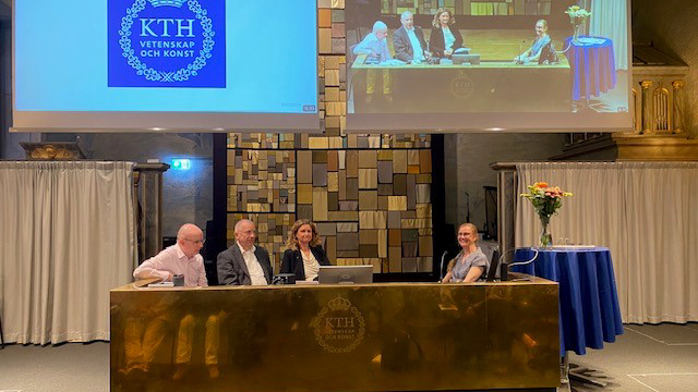 Fyra personer bakom ett stort guldpodium. En sitter mitt emot de andra.