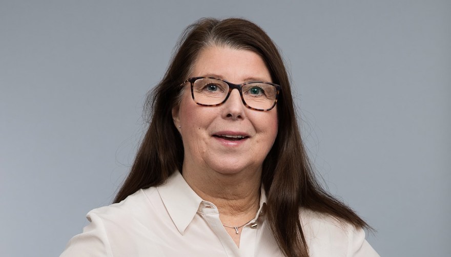 Kvinna, medelålders, brunt långt hår, glasögon, vit blus