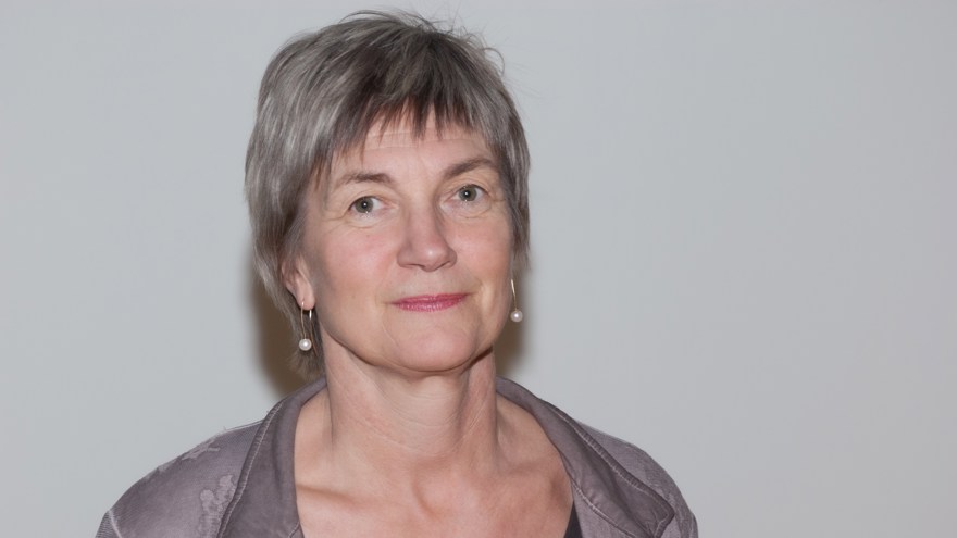 Kvinna, 60-års åldern, grått kort hår, grå kavajslag