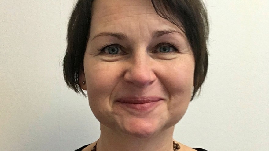 Kvinna, medelålders, kort, mörkt brunt hår.