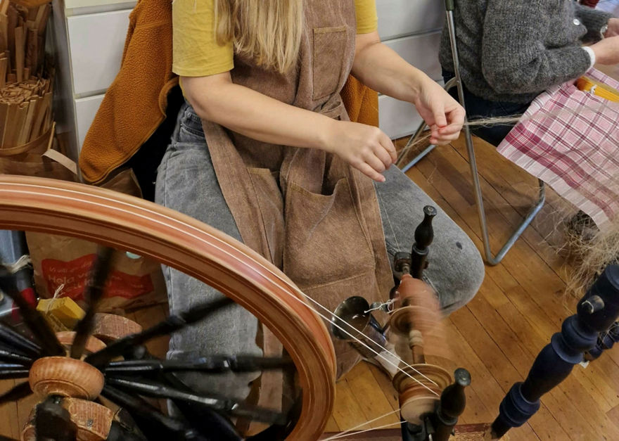 En person som spinner lin på spinnrock