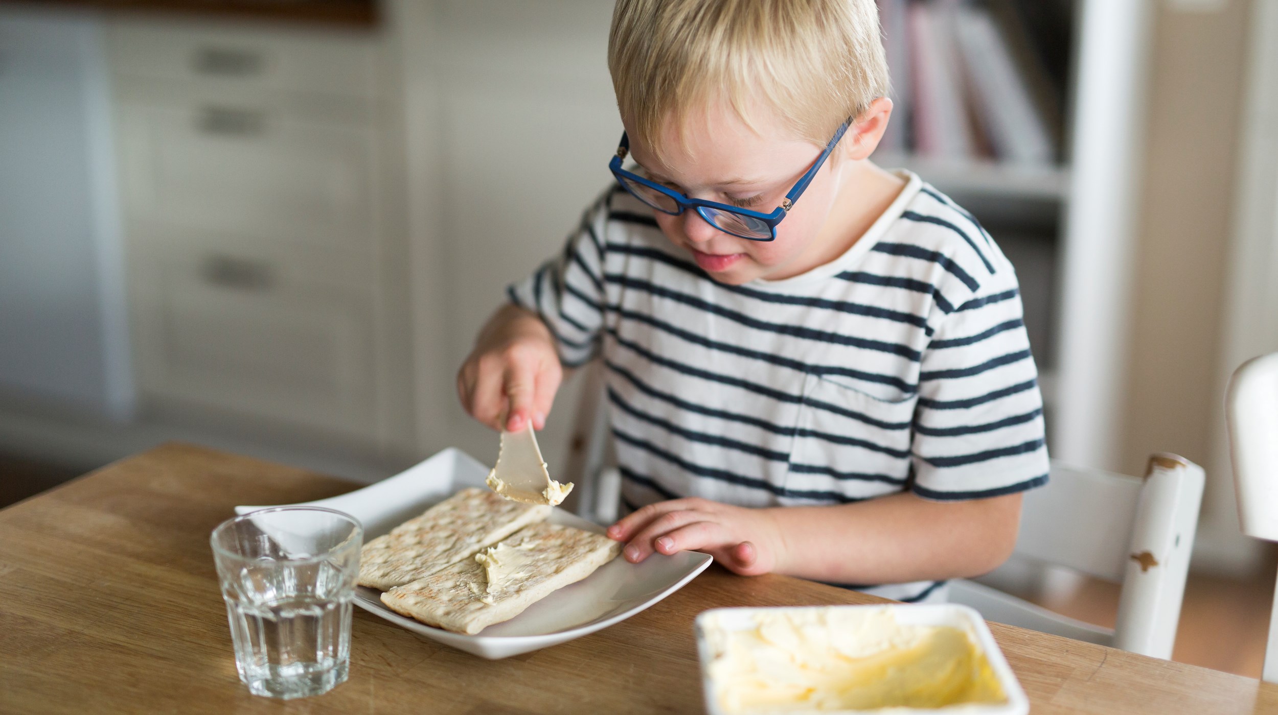 Pojke brer smör på smörgås