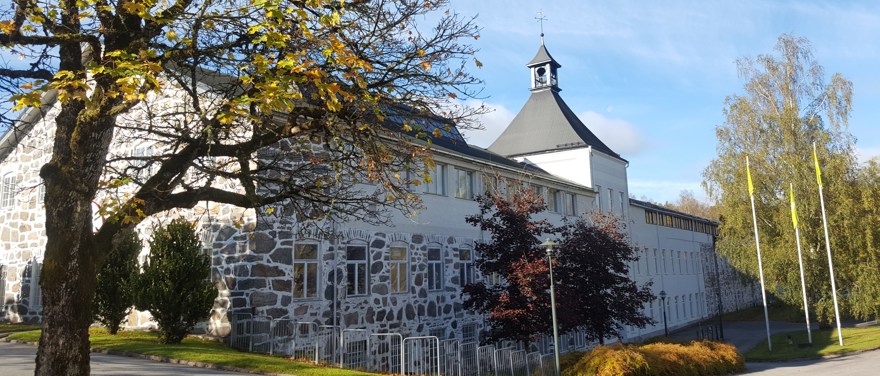 Rydals spinneri och museum. En vit stenbyggnad med mörkt tak och ett klocktorn.