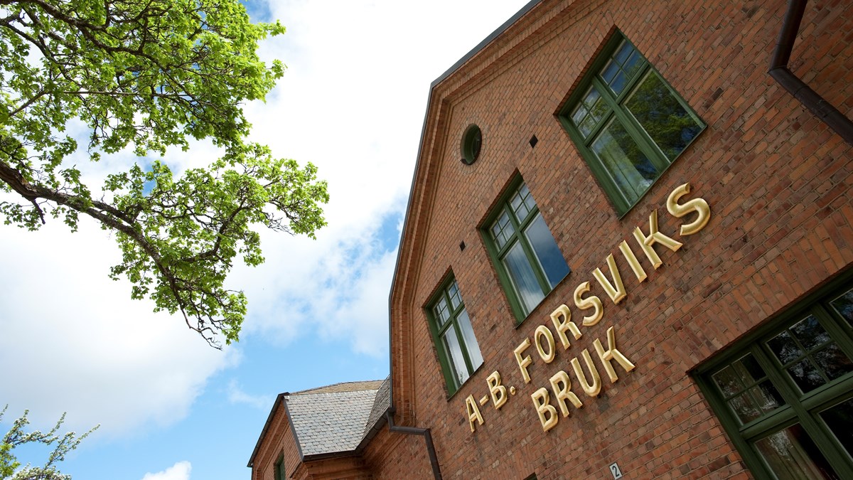 En bild på en brun tegelbyggnad med fasadtexten Forsviks bruk