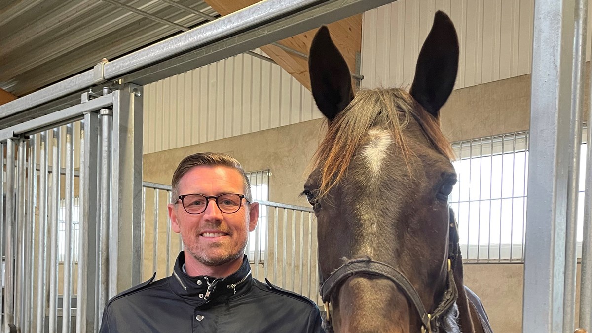 Rektor Niclas Dahlqvist och en häst i stallmiljö