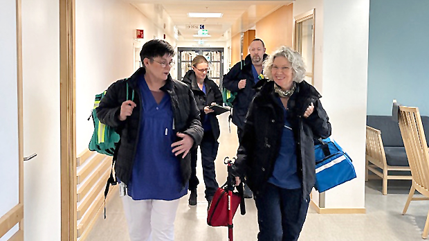 Närsjukvårdsteamet gående i korridor.