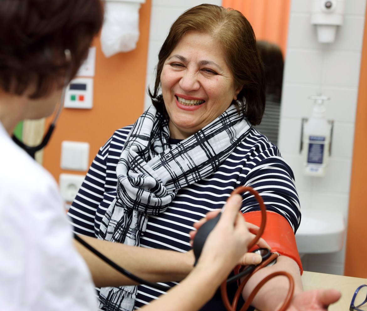 Vårdpersonal tar blodtryck på kvinnlig patient