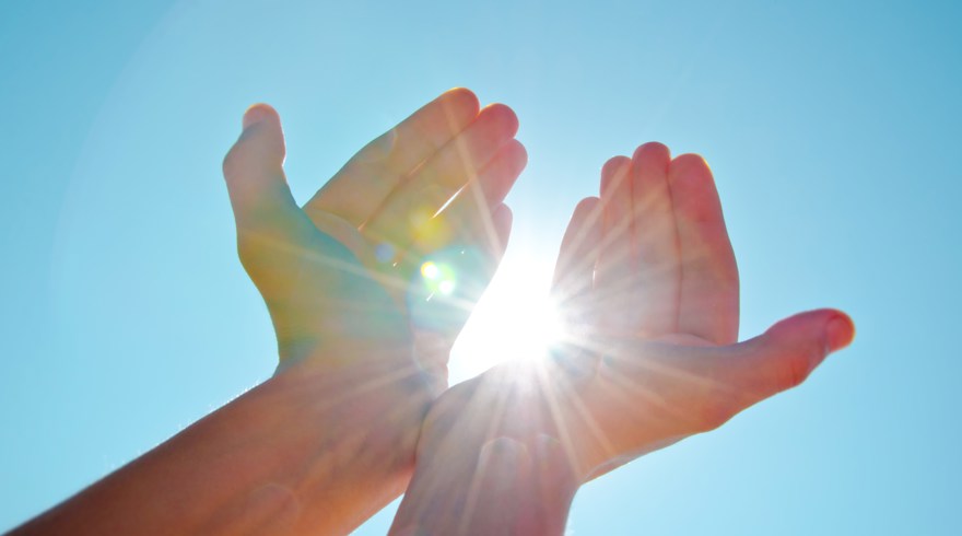 Solstrålar som fångas i två händer