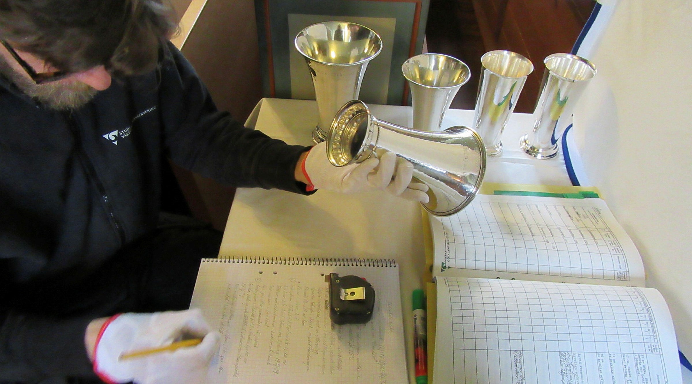 Metallkonservator gör inventarieförteckning över kyrksilver.