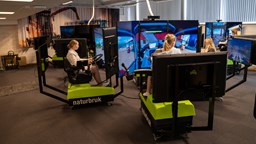 Elever sitter i simulatorer med skärmar