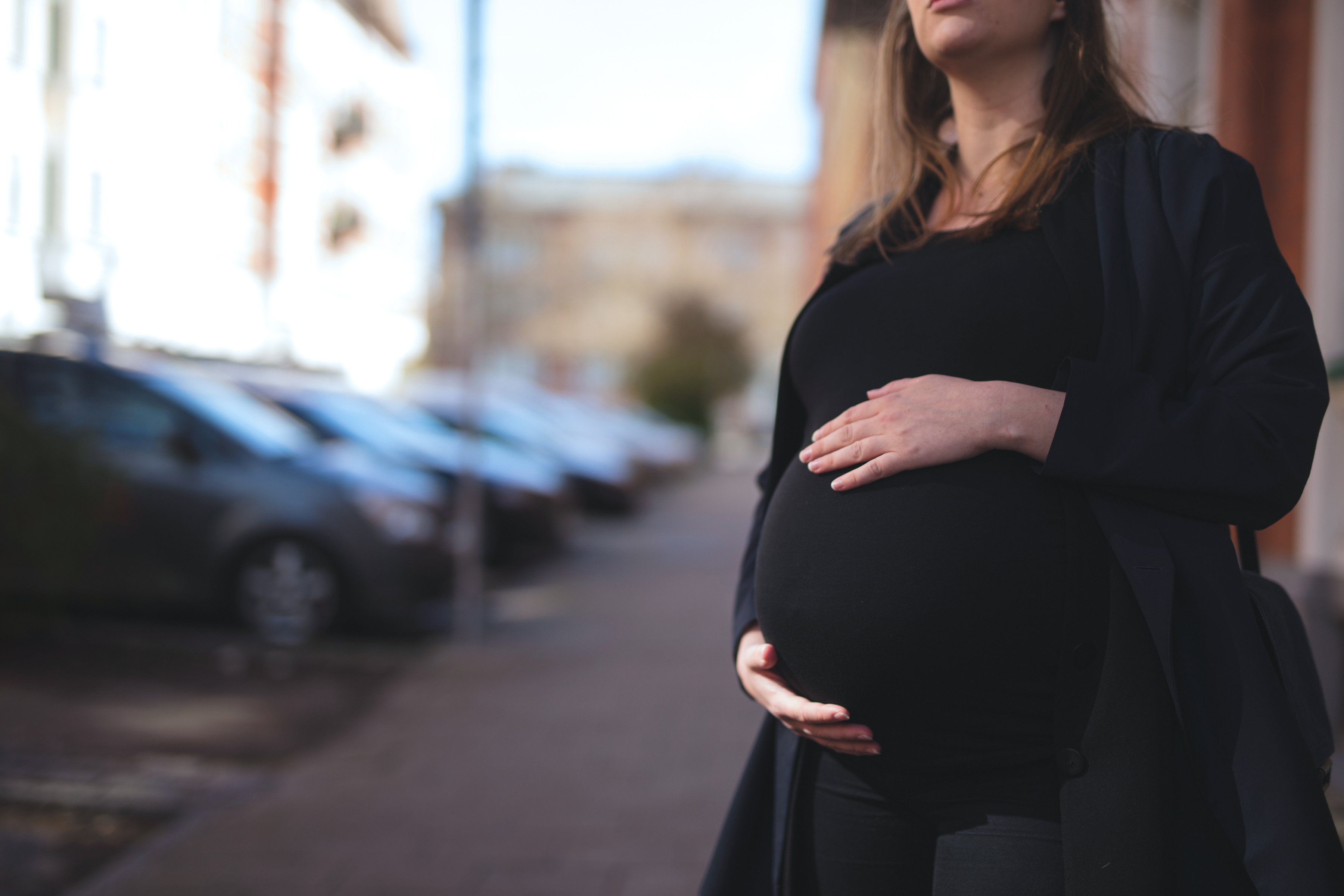 gravid som håller händerna på magen