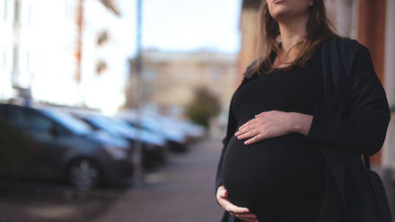gravid som håller händerna på magen