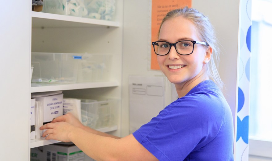 Sjuksköterska tar fram saker ur ett förråd.