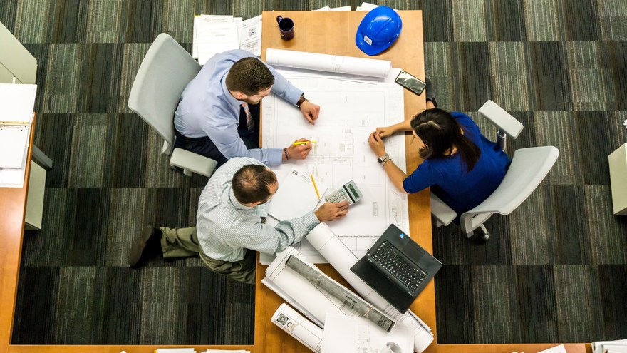 Möte med tre personer vid ett skrivbord sett uppifrån