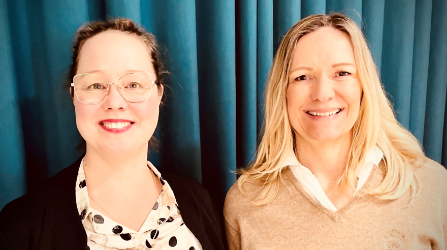 Mariana Hede har mörkt uppsatt hår, hon bär glasögon och en prickig blus. Vera Håkansson har blont långt hår och bär en beige v-ringad tröja.