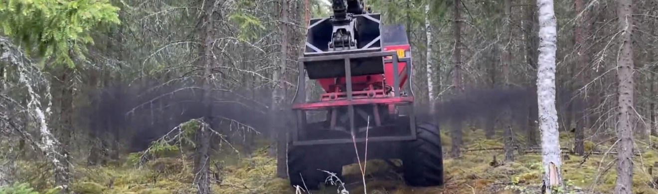 En skogsmaskin sprider ut aska i skogen