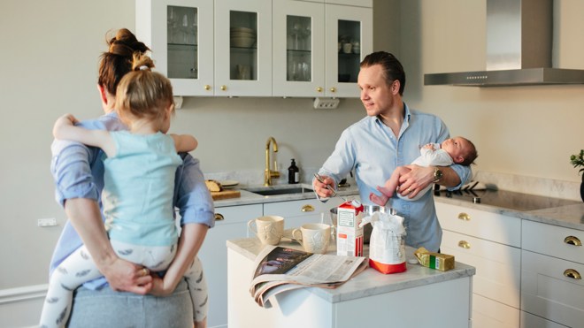 familj lagar mat runt köksö