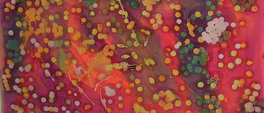 Röd färg med prickar av guld och grönt