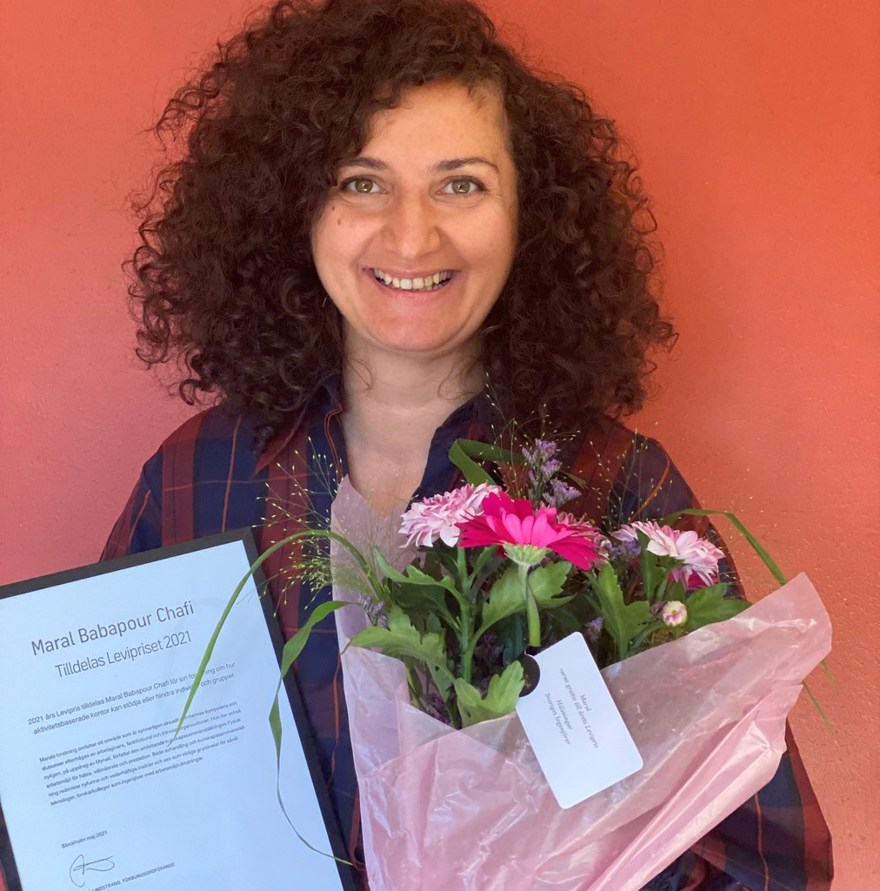 Kvinna med blommor och diplom