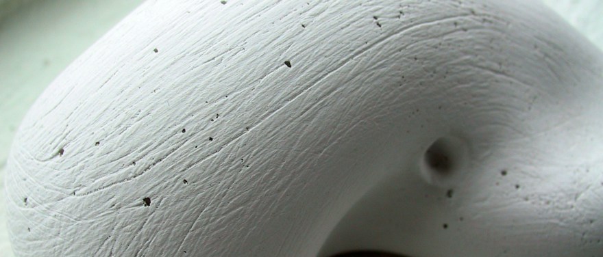 En gipsskulptur som är formad som en böna med ett litet hål