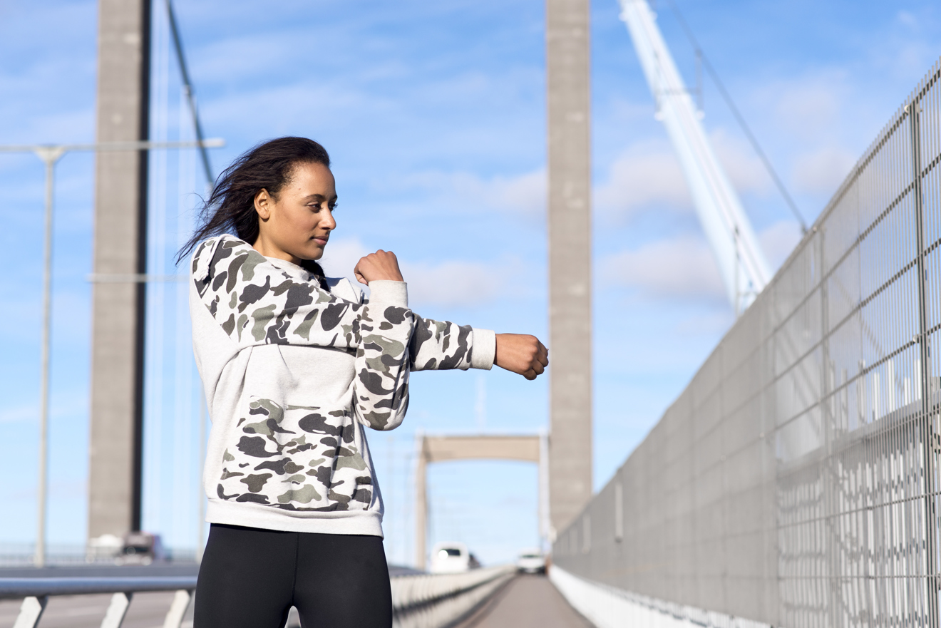 En person står på Älvsborgsbron och stretchar