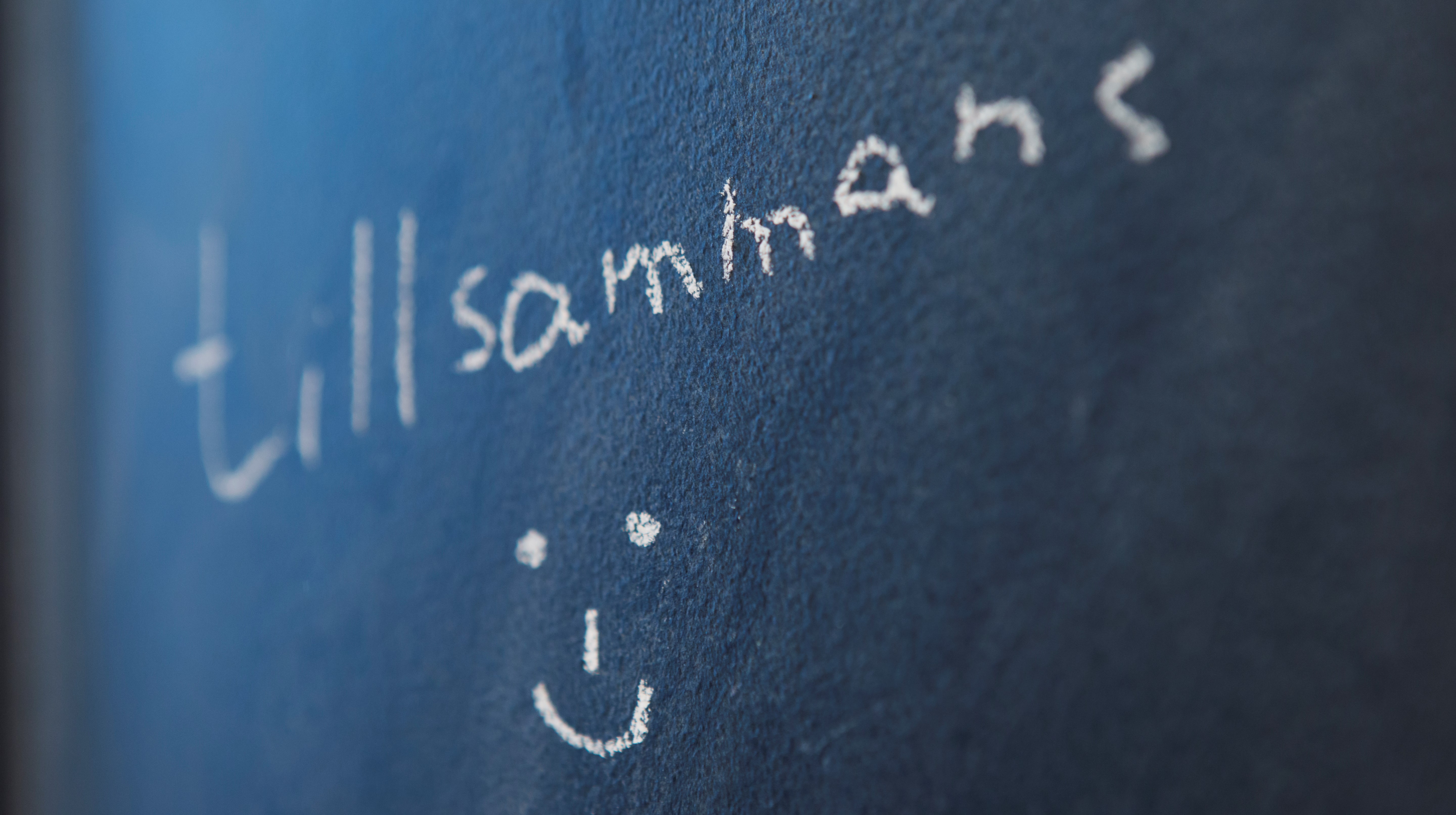 Text på svartatavlan med ordet tillsammans samt en glad gubbe