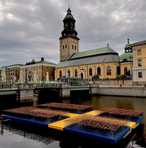 En utställning av drygt 6000 järnblommor på en pråm, med proportioner av en svensk flagga, i kanalen i Göteborg.