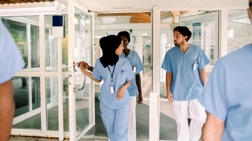 en grupp i sjukhuskläder går ut genom en dörr