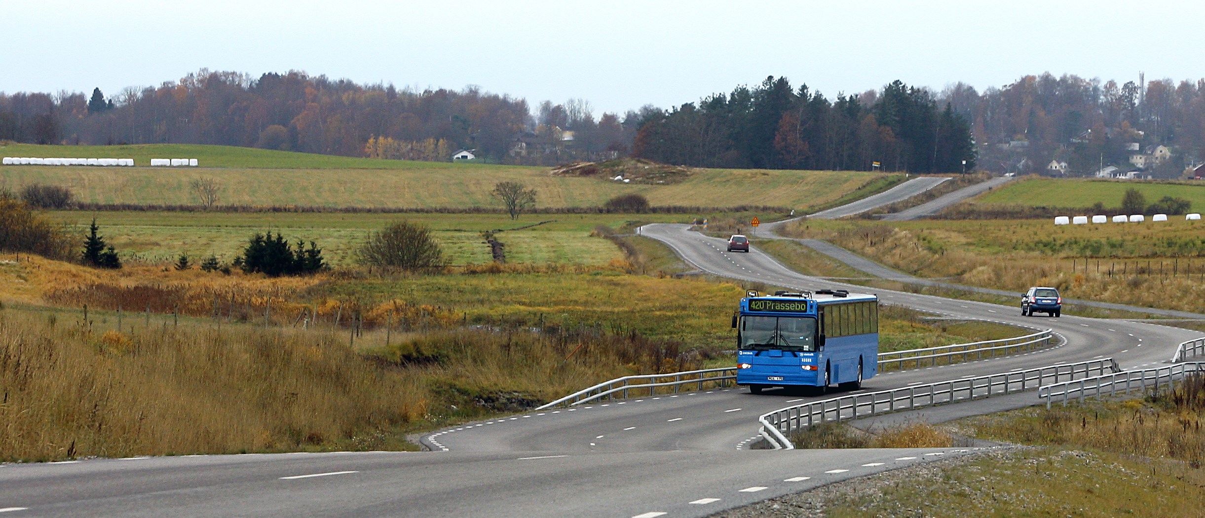 Blå buss på slingrande landsväg