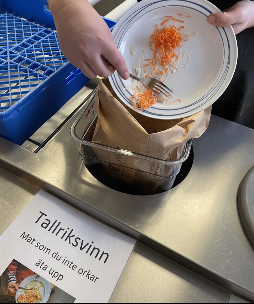 Matrester skrapas av en tallrik ner i en påse