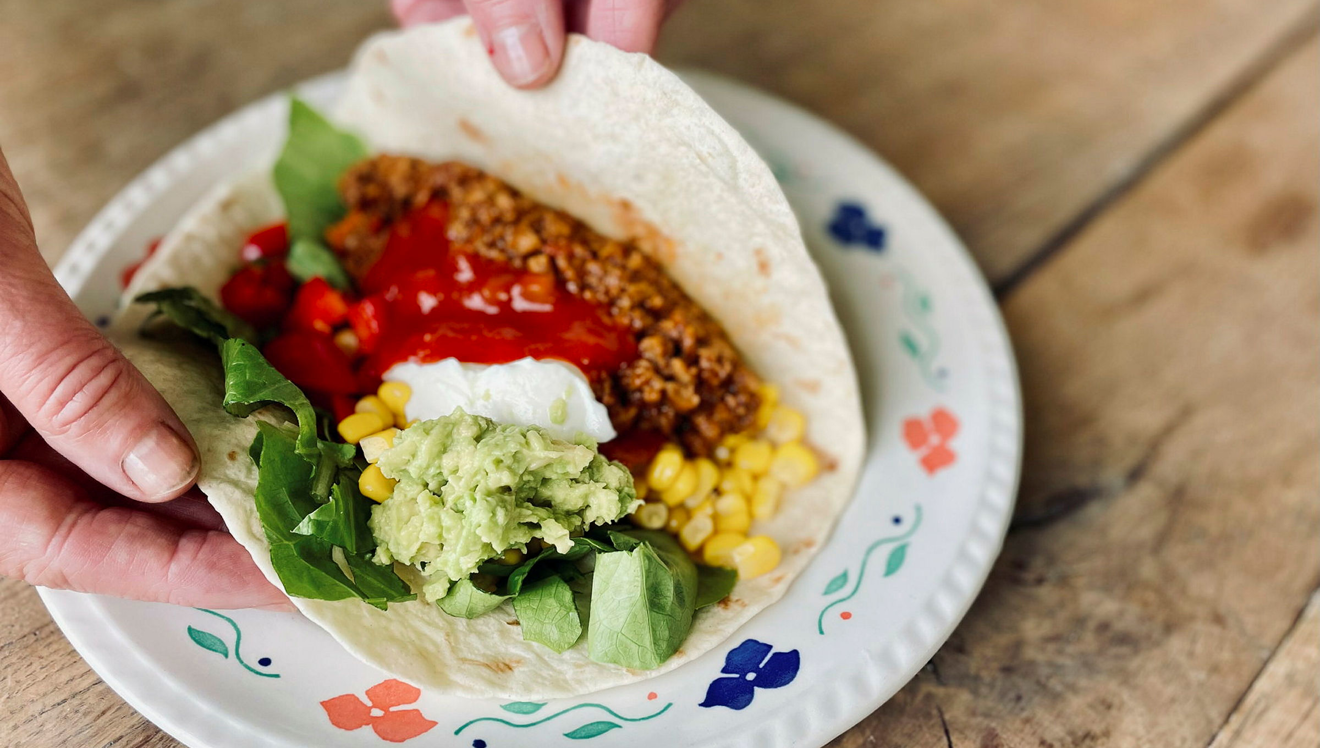 Tacofärs och blandade grönsaker i ett tortillabröd