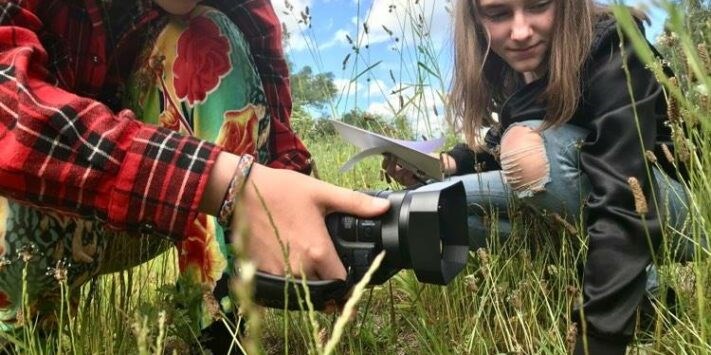 Två ungdomar filmar naturen