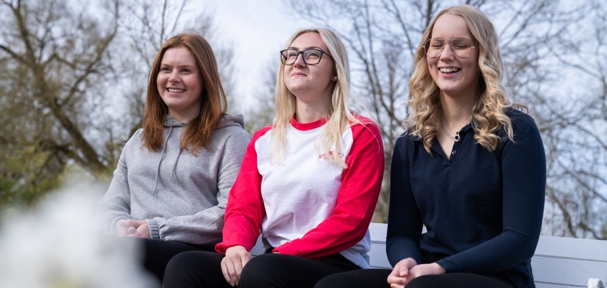 Elever som sitter på parkbänk