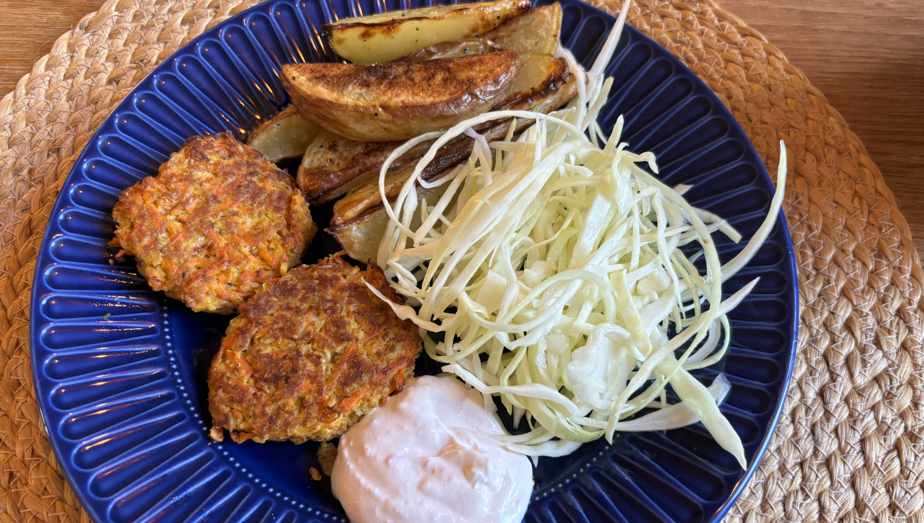 Linsbiffar med potatisklyftor och kål på en blå tallrik