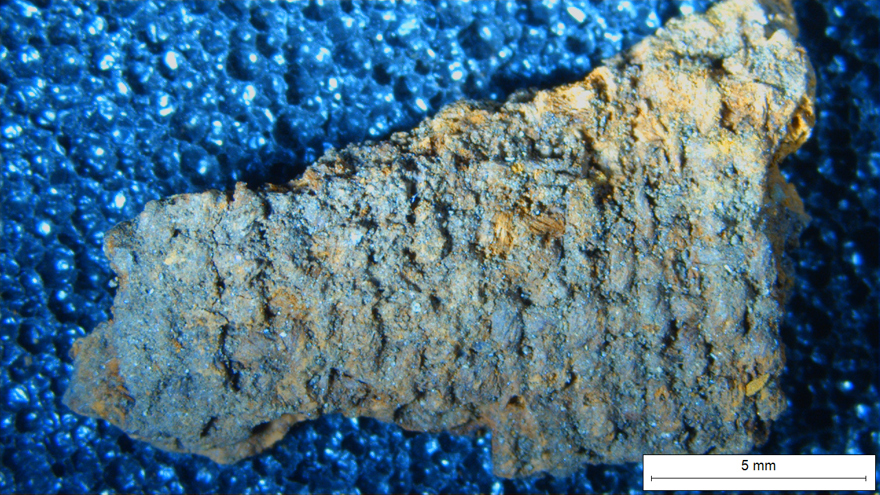 arkeologiskt funnet svärd. Starkare blå platta underst. Grönblå med lite senapsgula inslag överst