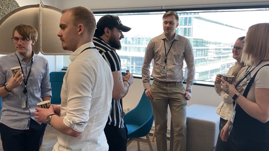 En grupp personer står upp och samtalar