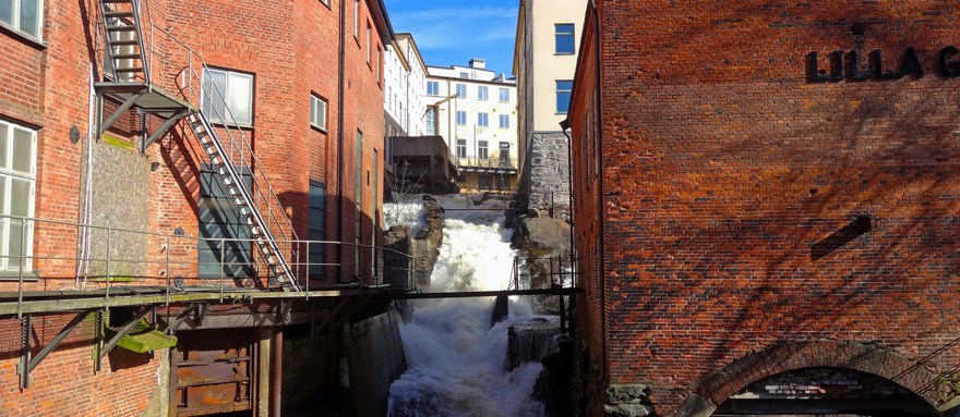 Forsande vatten i Mölndals kvarnby. Byggnaden är i rött tegel.