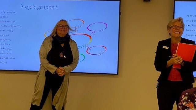 Två kvinnor framför en powerpoint-presentation