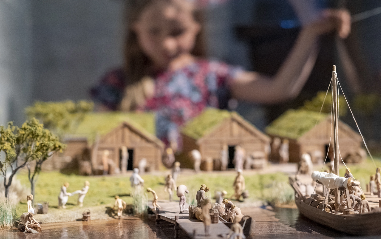 Person tittar på modell av Lödöses hamn